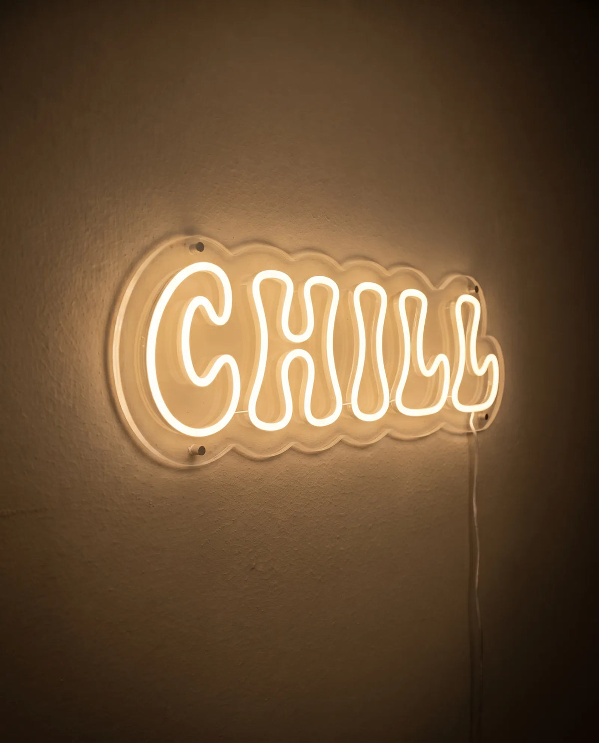 Néon LED vu de trois-quarts, plexiglas cristallin découpé en vagues autour des lettres chill