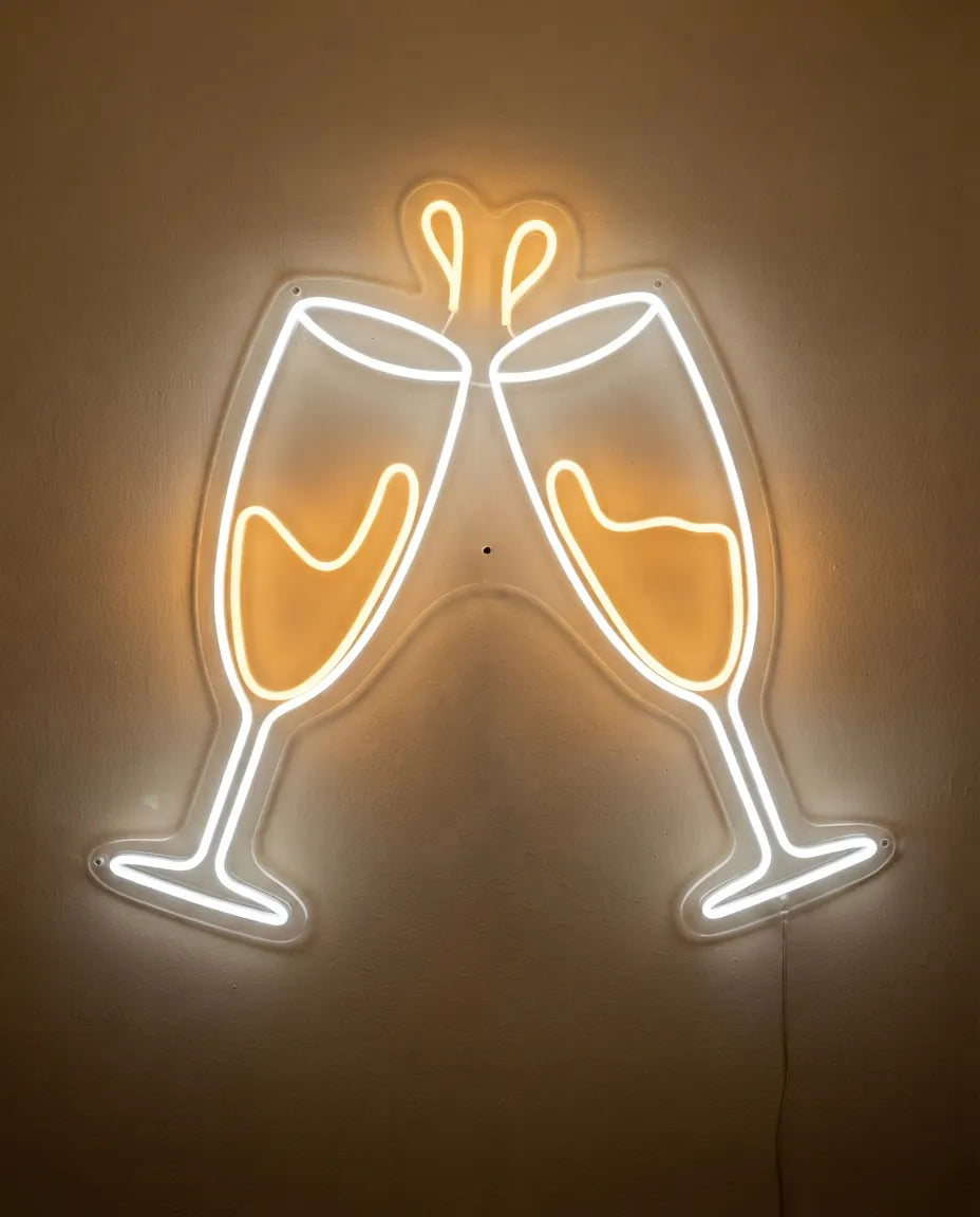 Néon champagne de face sur mur peint, deux flûtes au contour blanc froid remplies de blanc chaud