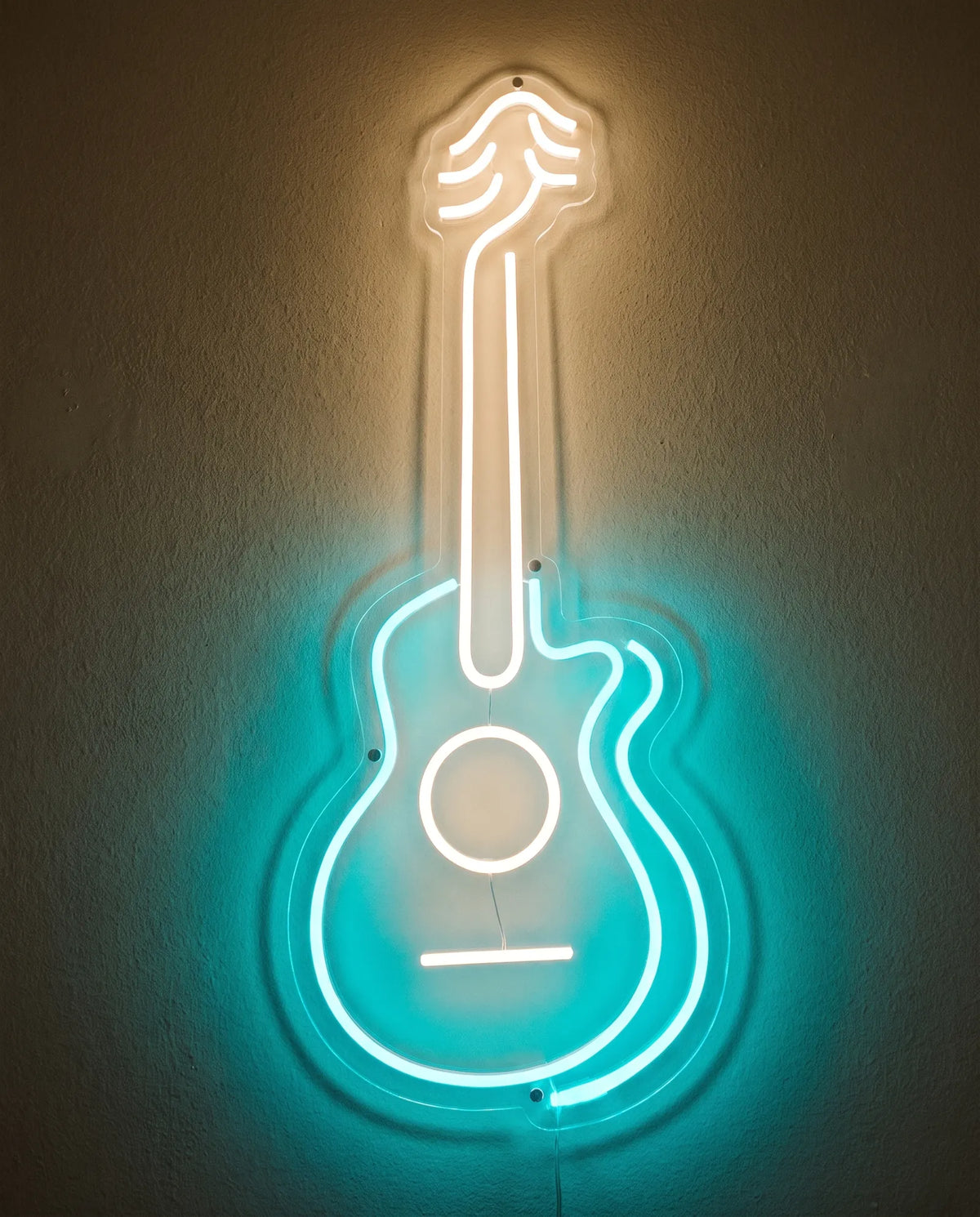Néon guitare acoustique de face sur mur peint, corps turquoise, rosace et manche blanc chaud