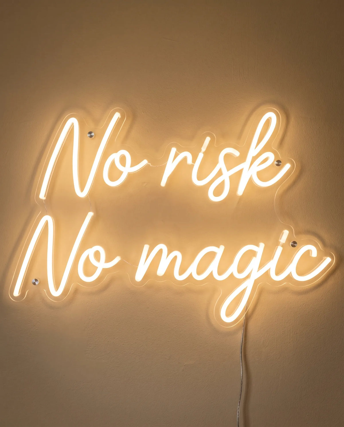 Néon No Risk No Magic de face sur mur peint, devise manuscrite sur deux lignes