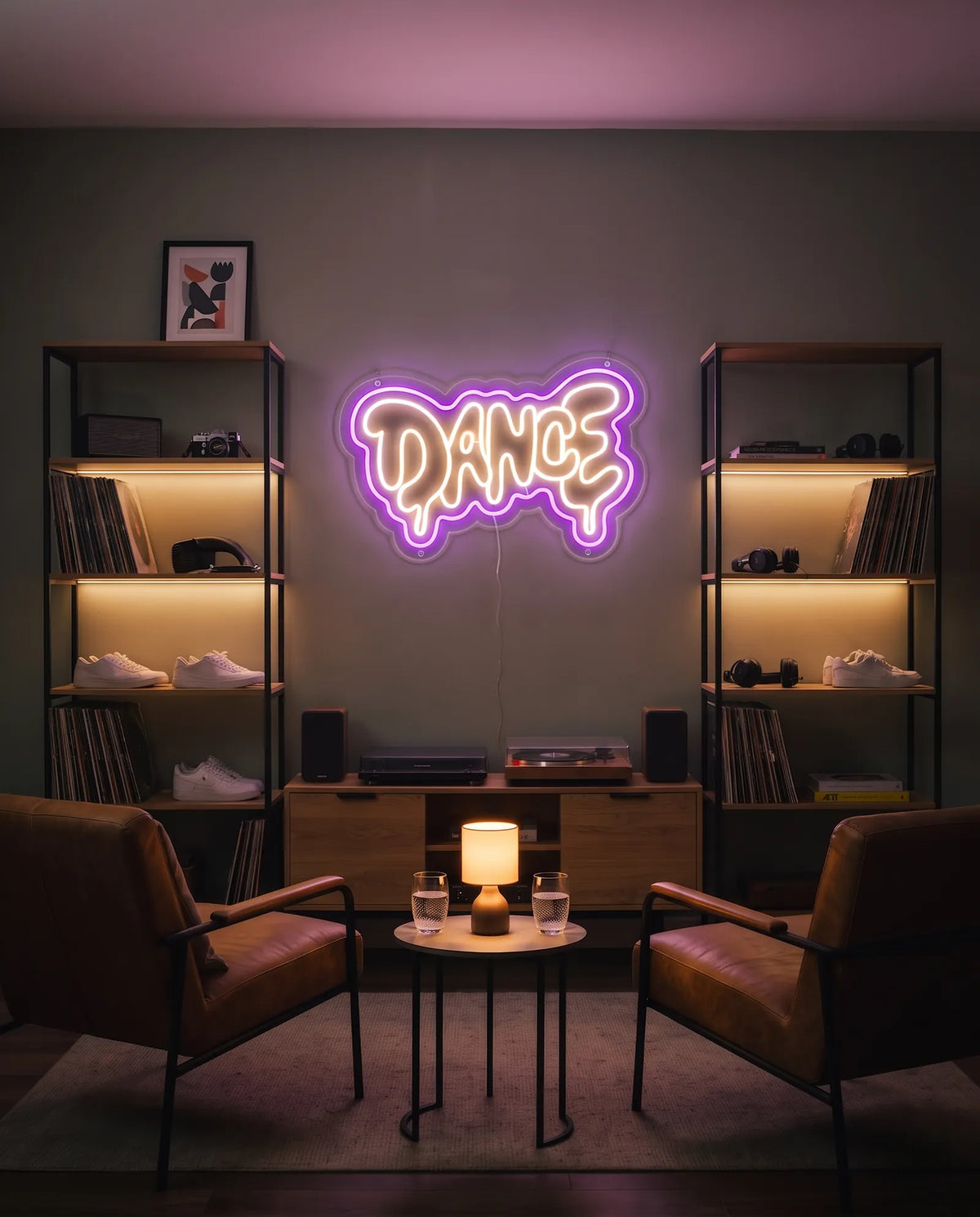 Néon LED dance au-dessus de deux platines vinyles, enceintes, fauteuils en cuir et étagères de disques