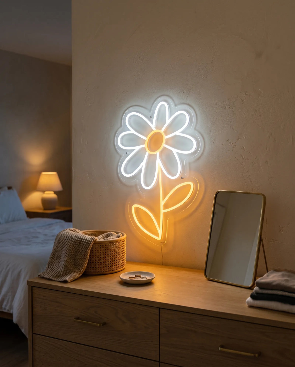 Néon fleur blanc et doré sur le mur d’une chambre, commode en chêne, coupelle à bagues et miroir doré
