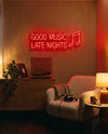 Néon Good Music Late Nights rouge allumé au-dessus d’une platine, fauteuil bouclette avec casque et lampe