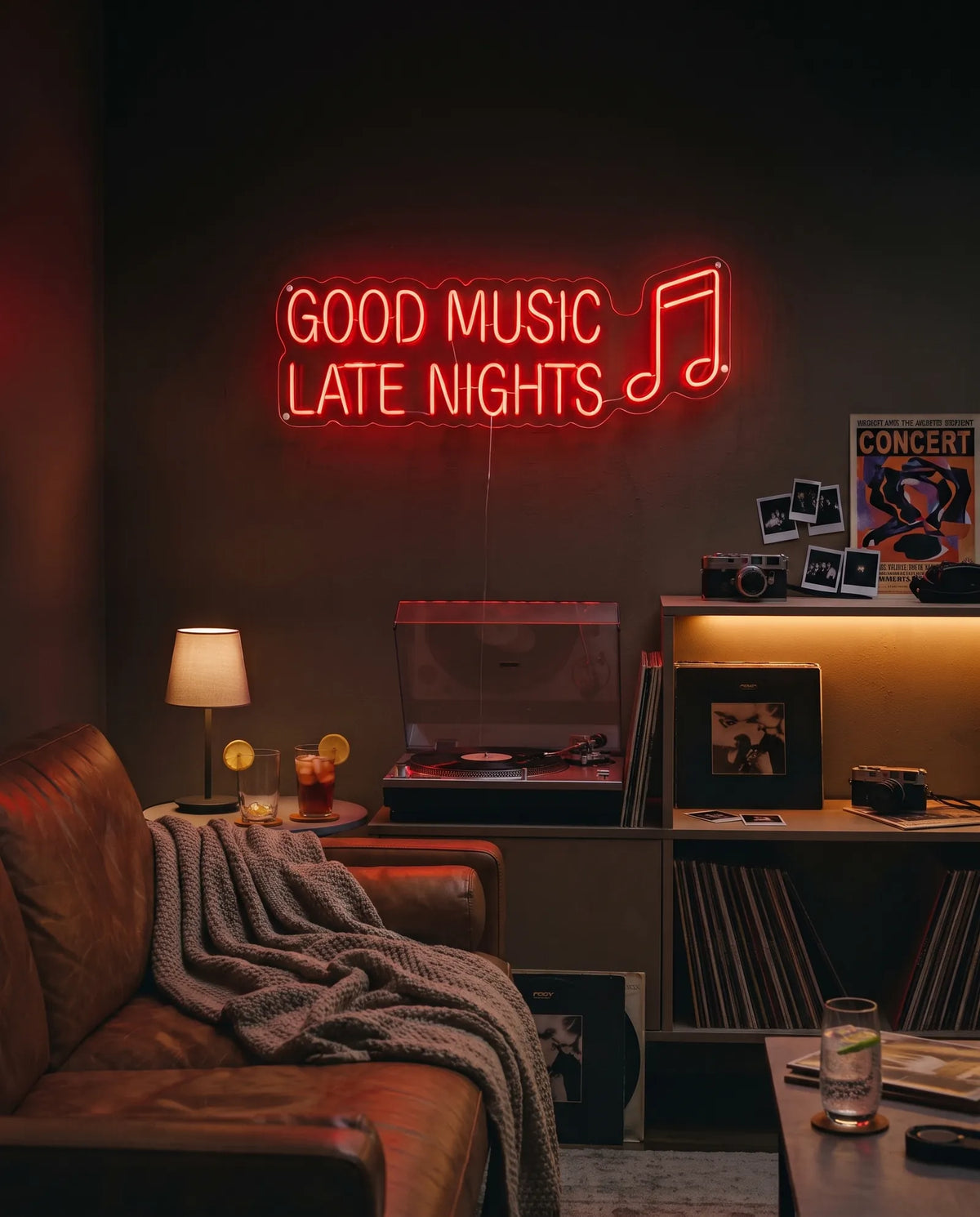 Néon LED Good Music Late Nights dans un salon sombre, canapé en cuir, vinyles et verres glacés au citron