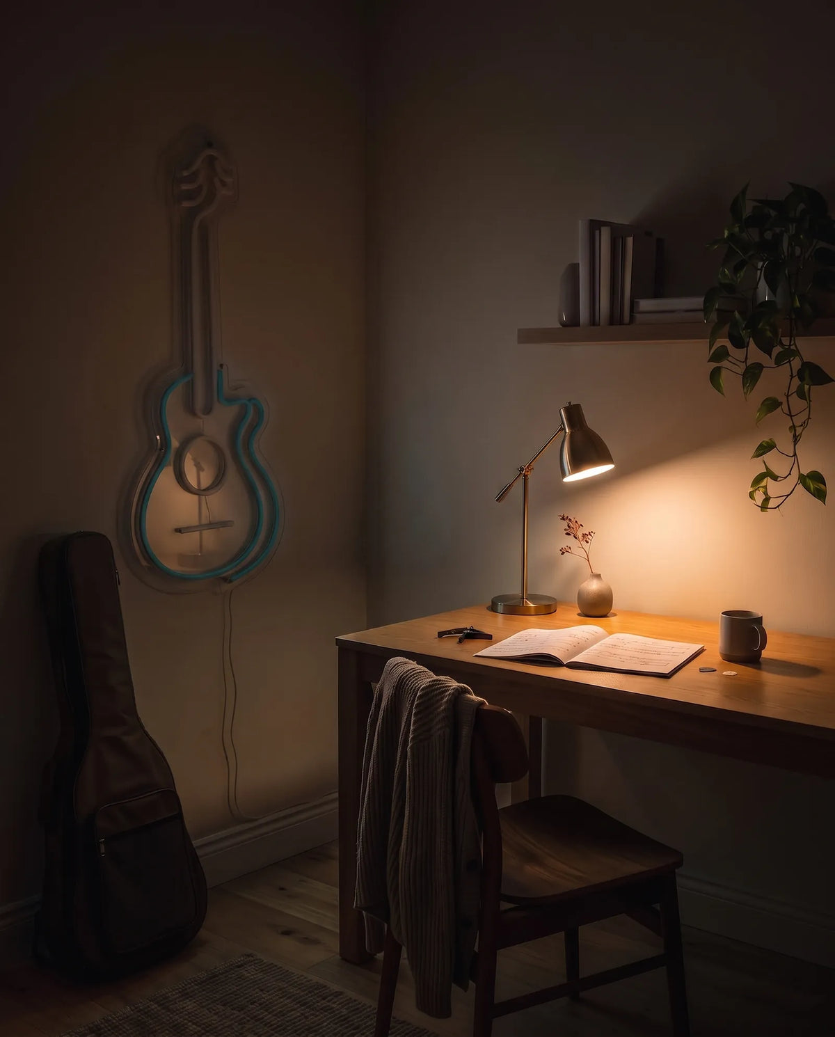 Néon guitare acoustique éteint au-dessus d’un bureau en bois, lampe en laiton allumée sur la partition ouverte