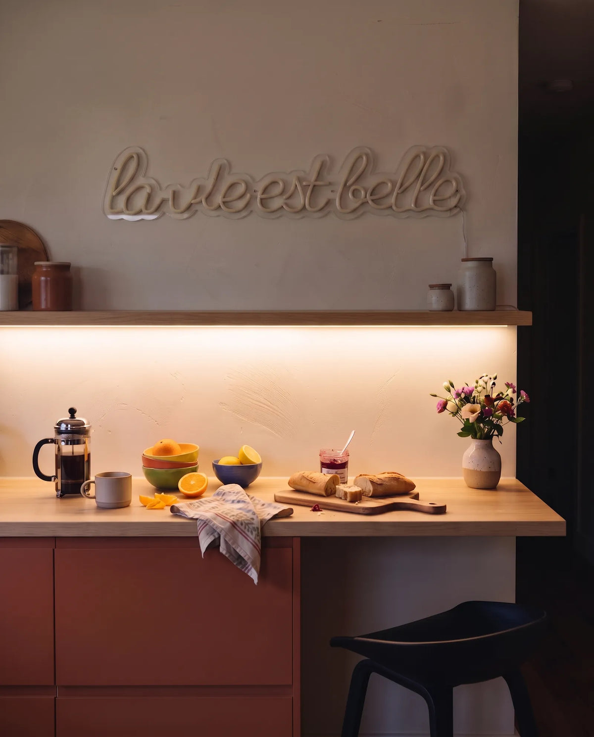 Néon la vie est belle éteint dans une cuisine le matin, plan de travail en bois et bouquet de fleurs