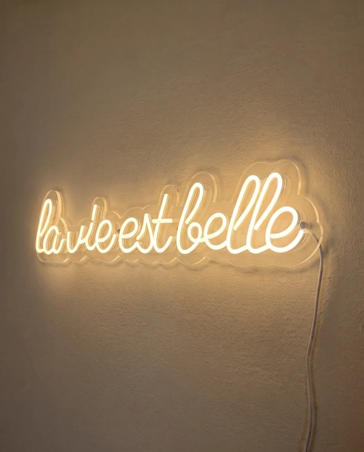 Néon LED vu de trois-quarts, plexiglas cristallin découpé au contour de la phrase manuscrite