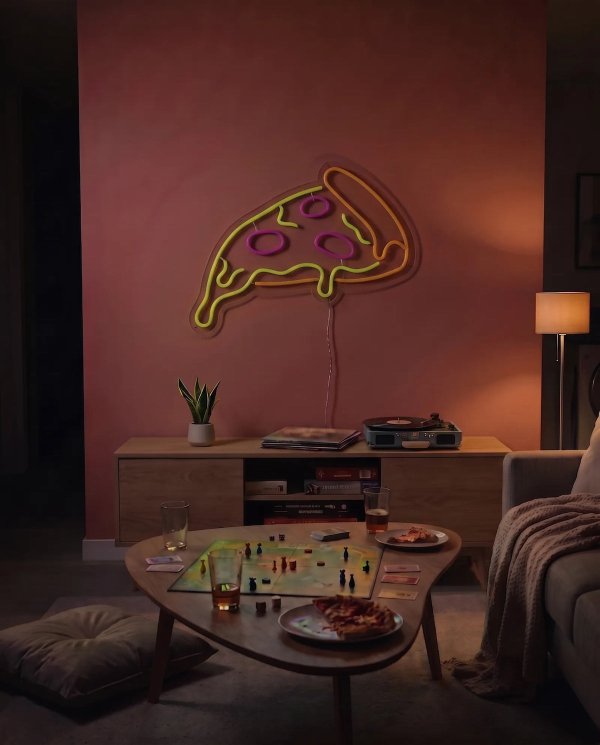 Néon part de pizza éteint au-dessus d’un meuble télé en bois, platine vinyle et plante, salon le soir